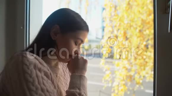年轻女子哭着透过窗户看生活和健康问题抑郁视频的预览图