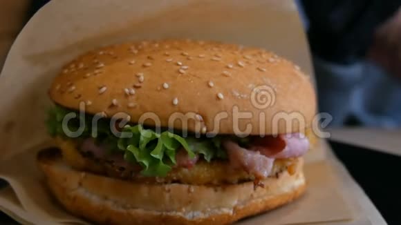 快餐店的桌子上摆着美味多汁的新鲜汉堡沙拉叶鲜面包肉切片不健康酱汁视频的预览图