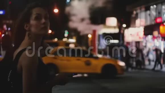 大气拍摄的快乐白种人年轻当地妇女使用智能手机应用程序在黑暗繁忙的纽约夜街交叉视频的预览图