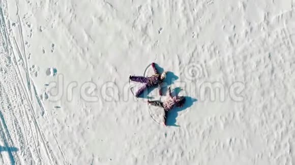 从上面可以看到孩子们躺在白雪上阳光明媚让白雪天使视频的预览图