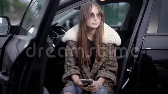 年轻女人在车里用智能手机视频的预览图