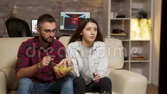 白人夫妇在看电视时吃薯条视频的预览图