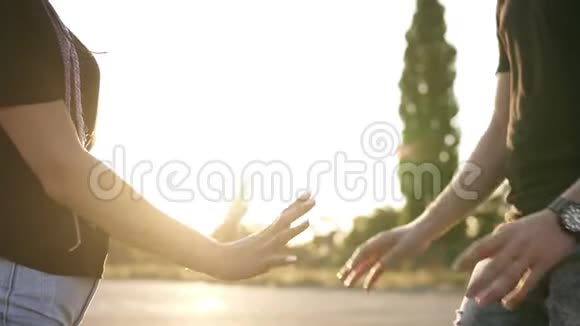 街上的年轻夫妇牵着手穿着牛仔衬衫和黑色T恤站在外面顶着太阳视频的预览图