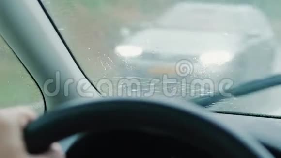 前面的屏幕上有雨滴在驾驶车上交通会议视频的预览图