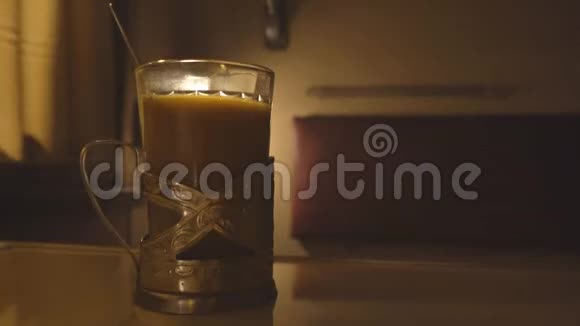 一杯茶在火车车厢的桌子上晚上火车旅行概念复制空间视频的预览图