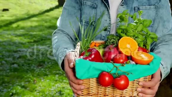 一个快乐的年轻农民把新鲜蔬菜放在篮子里的肖像关于自然的背景视频的预览图