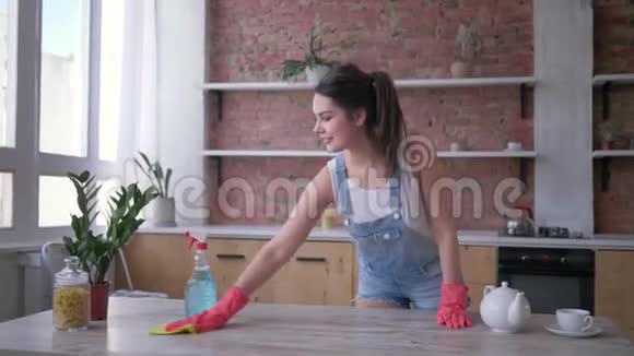 戴着橡胶手套的幸福管家女孩在料理和家务中的肖像视频的预览图