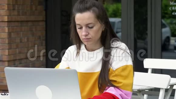 年轻女子在户外使用笔记本电脑视频的预览图