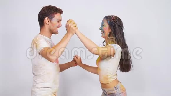 年轻夫妇和霍莉一起跳舞在白色的背景上画画社会舞蹈概念视频的预览图