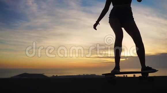 一个滑板手的剪影在日落的天空中慢动作稳定的镜头视频的预览图