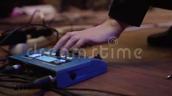 音乐家在演出前调整吉他处理器按下CPU上的按钮视频的预览图