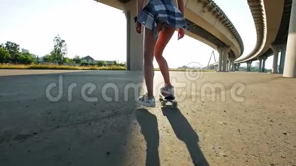 美丽苗条的女孩骑着滑板稍微从滑板上摔下来但被抱在地上视频的预览图