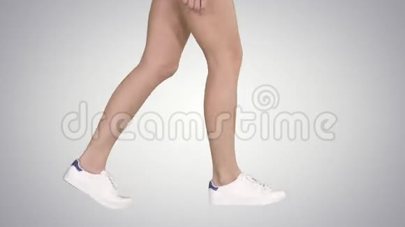 穿着渐变运动鞋的女性脚在渐变背景下行走视频的预览图
