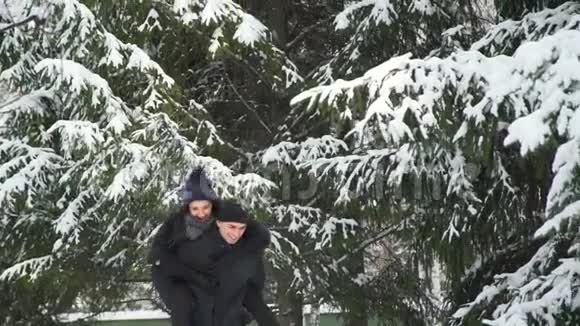 年轻女子骑着男子在冬季公园视频的预览图