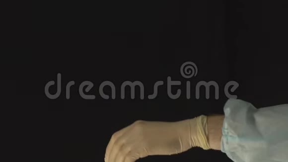 外科医生在手术后脱下医用手套黑色背景特写医疗医疗慢动作视频的预览图