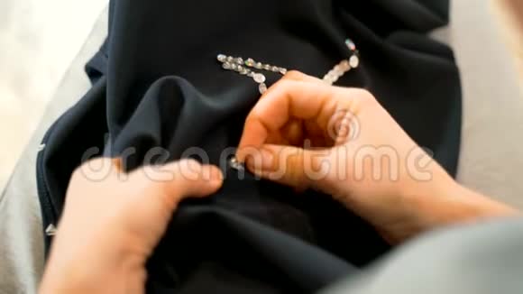 女人在裙子上缝亮片女孩手中的针线自由工作在家创造新衣服视频的预览图