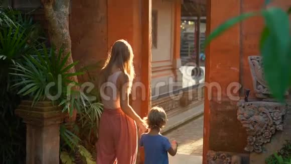 一位美丽的年轻女子和她的小儿子慢镜头穿过普里撒伦王宫的大门视频的预览图