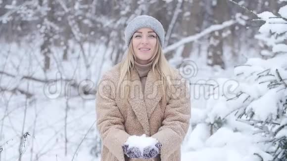 圣诞节和寒假的概念快乐的女人在冬天的森林里扔雪视频的预览图
