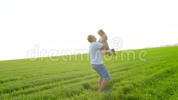 父亲在绿茵场上抛洒幸福的童女女儿空气夕阳爸爸和小女儿玩他扔了视频的预览图