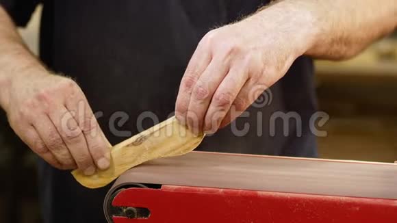 木匠的手在磨床上磨平木制零件手工制作概念视频的预览图