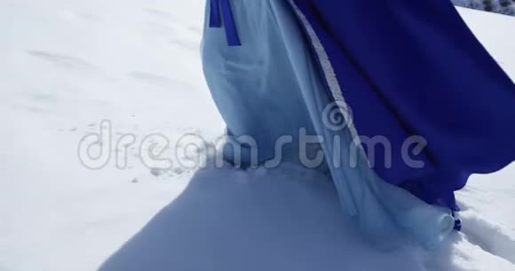 穿蓝衣服的女人在雪地上行走视频的预览图