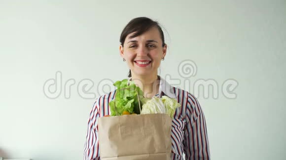 快乐的年轻女人拿着蔬菜包视频的预览图