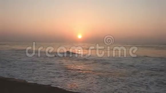 海滩上灿烂的金色夕阳沙滩上的浪花贝壳海洋清澈金色的阳光反射在海滩上孙世宁视频的预览图