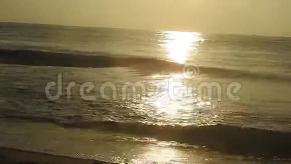 渔船在后路美丽的金色日落在海滩上与渔民美丽的金色夕阳在海滩上与渔夫视频的预览图