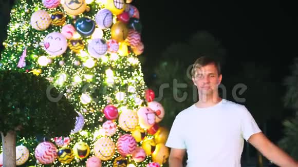热带城市圣诞树和棕榈树背景下的快乐男人新年旅行的概念视频的预览图