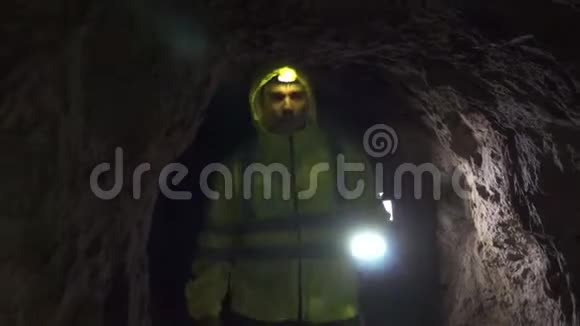 肖像探索者志愿者手里拿着手电筒在洞穴里搜寻视频的预览图
