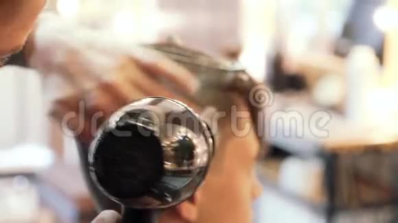 理发师用吹风机在理发后给一个人吹头发视频的预览图