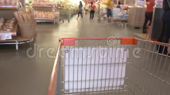 女人的手在超市的手推车里放一条面包特写视频的预览图
