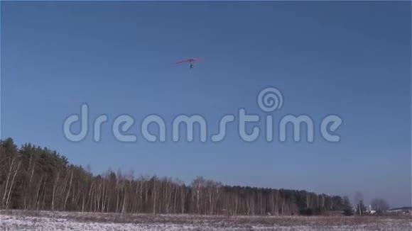 一架悬挂式滑翔机降落在白雪覆盖的草地上视频的预览图