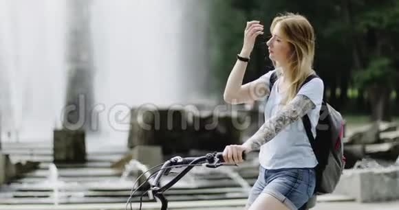 有魅力的女孩骑着自行车在公园里享受大自然视频的预览图