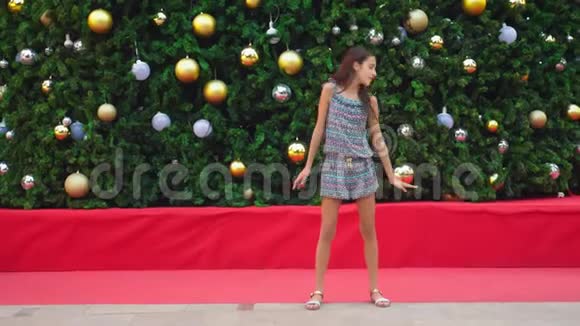 在热带城市的圣诞树和棕榈树的背景下跳舞的快乐女孩新年的概念视频的预览图