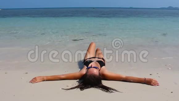 泰国海湾的一个小岛上美丽的女孩在白色的海滩上休息视频的预览图
