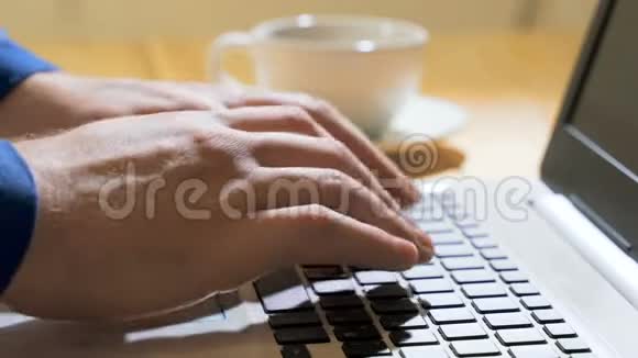 在笔记本电脑上工作在键盘上打字现代办公业务男人穿着米色毛衣的手视频的预览图