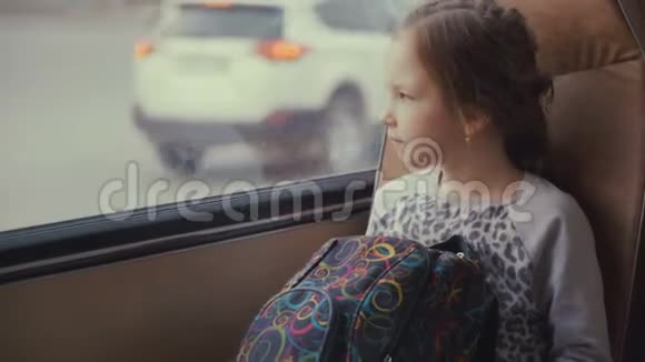 年轻漂亮的女乘客在移动校车上带着书包在她的智能手机和社交网络上使用社交网络视频的预览图
