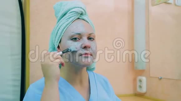 女人的脸头上有毛巾皮肤面具上有刷子平均计划视频的预览图