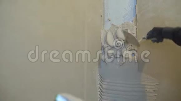 施工人员用抹刀在竖墙上抹灰泥的特写视频的预览图