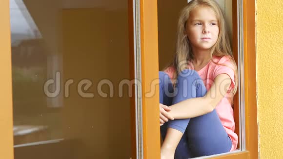 伤心的女孩坐在家里的窗台上少女窗外挥手问好视频的预览图