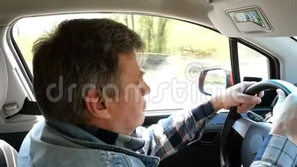 成年男子开着他的车转动方向盘惊讶地看着前方视频的预览图