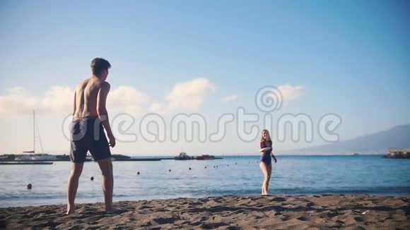 一个年轻人和他的女朋友在海滩上玩飞盘视频的预览图