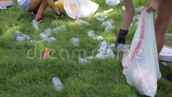志愿者清理园区垃圾人们在草地上捡一瓶塑料视频的预览图