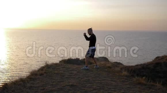 体育活动肌肉拳击手在比赛前在近海的山上完成打击视频的预览图