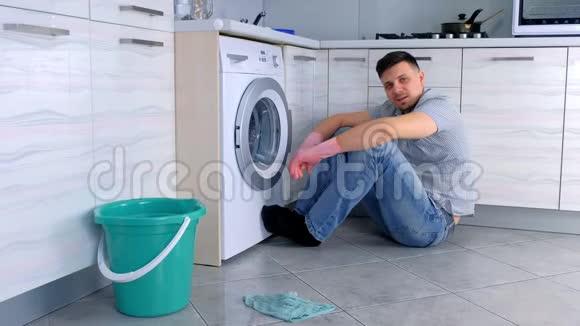 戴橡胶手套的人可以休息一下不用坐在厨房的地板上打扫卫生视频的预览图