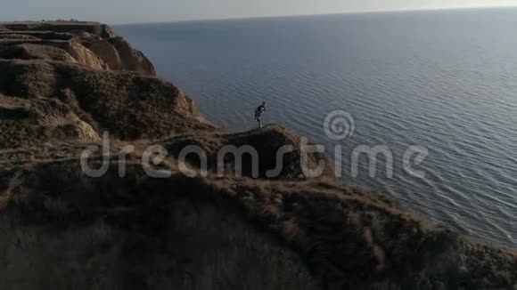 武术在美丽的风景中运动员在海上的山上在明亮的阳光下在水面上与天空交战视频的预览图