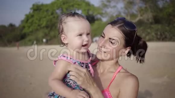妈妈和女儿在海边的海滩上亲密无间4k视频的预览图