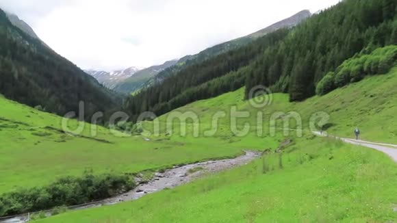 人们徒步穿越奥地利蒂罗尔州的Schoenachtal山谷农田和山脉视频的预览图
