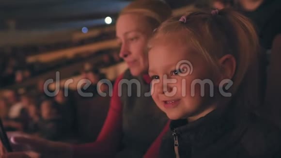 妈妈和她的小女儿正在看马戏表演高兴地拍手视频的预览图